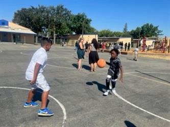 Two students playing basketball