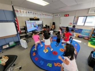 Nine kindergarten students dancing at circle time